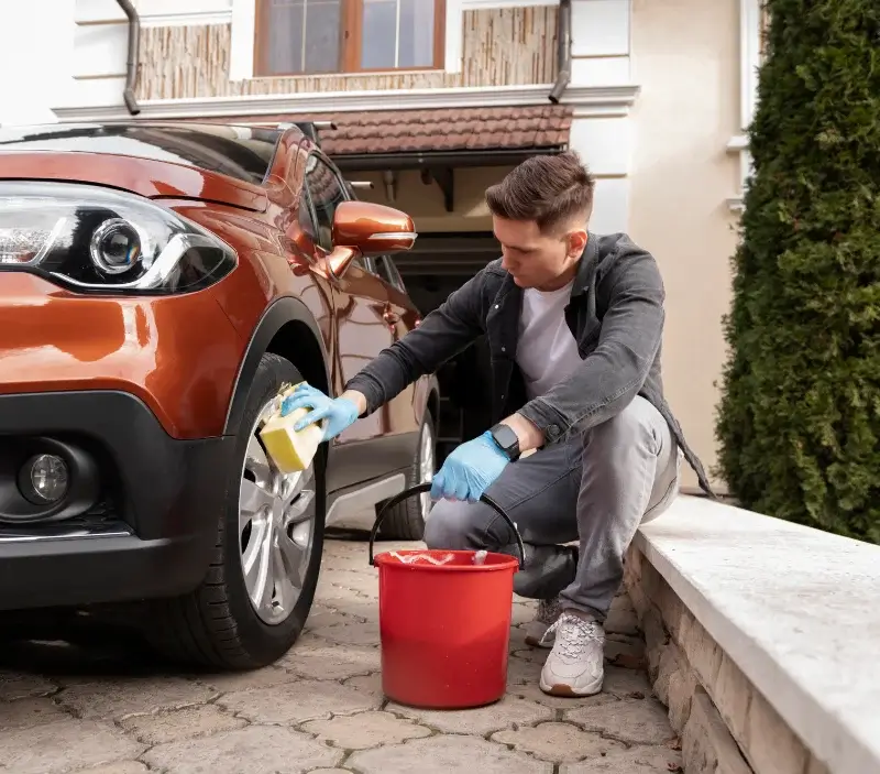 Lavage auto à domicile Castelnau-de-Mandailles : professionnel intervenant sur un véhicule